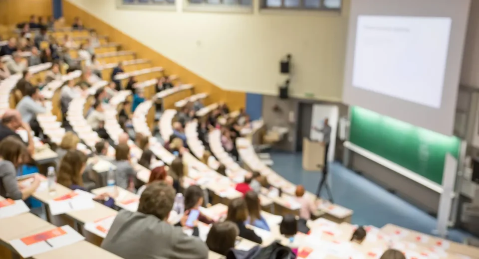 Students attending a university lecture in a large auditorium