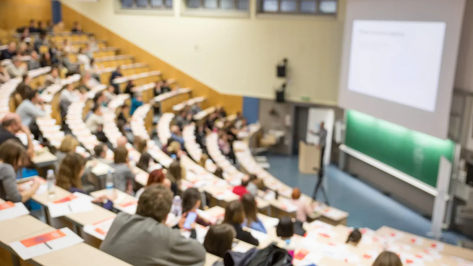 Students attending a university lecture in a large auditorium