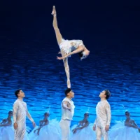 Female acrobat performing the Shoulder Ballet during the SWAN acrobatic dance drama.