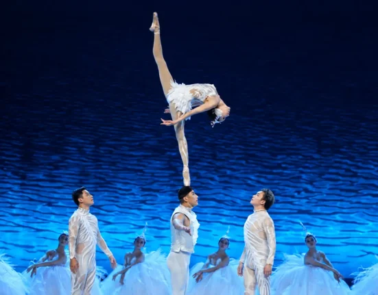 Female acrobat performing the Shoulder Ballet during the SWAN acrobatic dance drama.