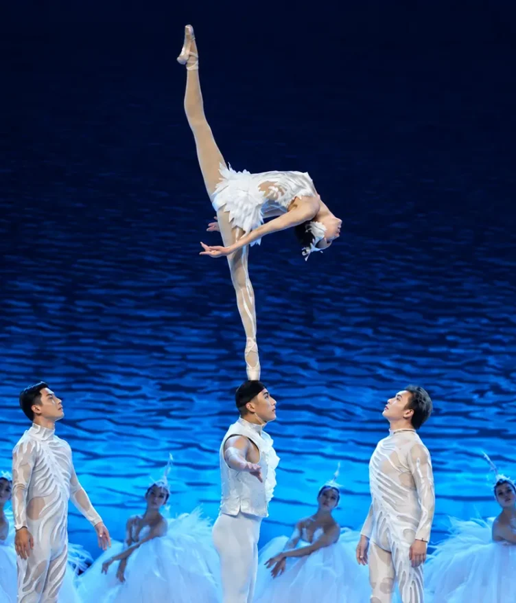 Female acrobat performing the Shoulder Ballet during the SWAN acrobatic dance drama.