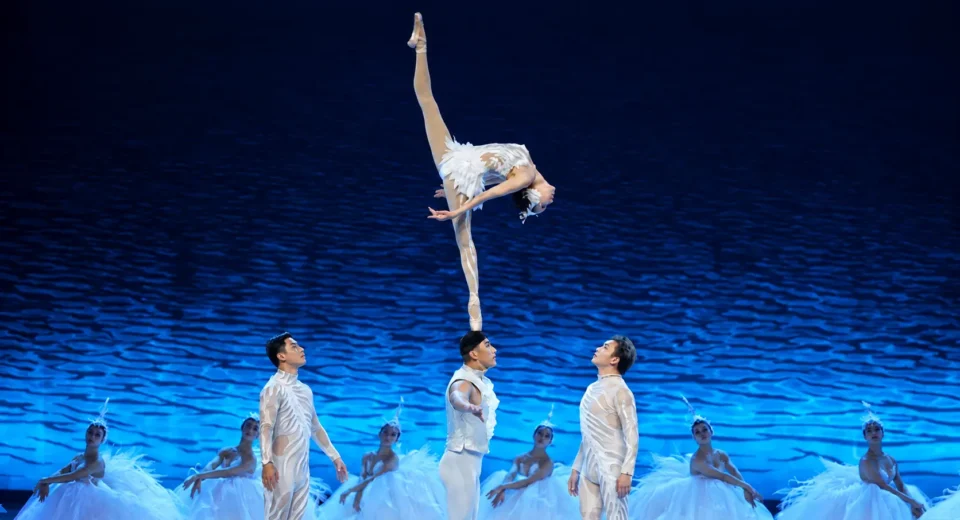 Female acrobat performing the Shoulder Ballet during the SWAN acrobatic dance drama.