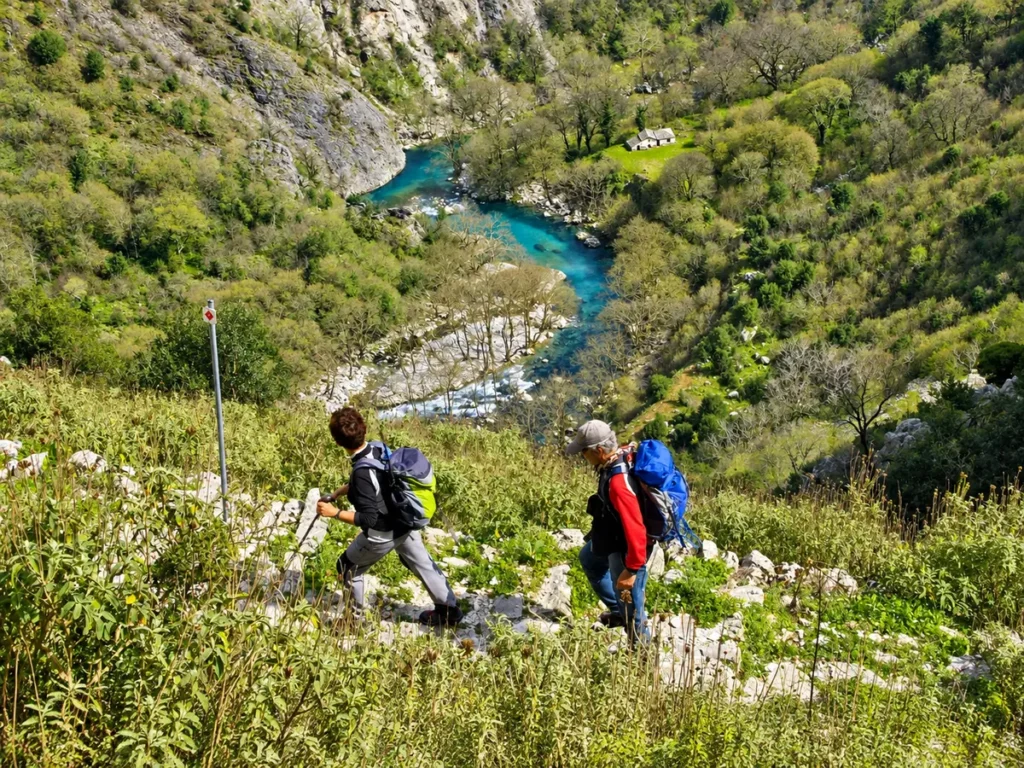 Hikers descending towards the Voidomatis River in Vikos Gorge, Zagori