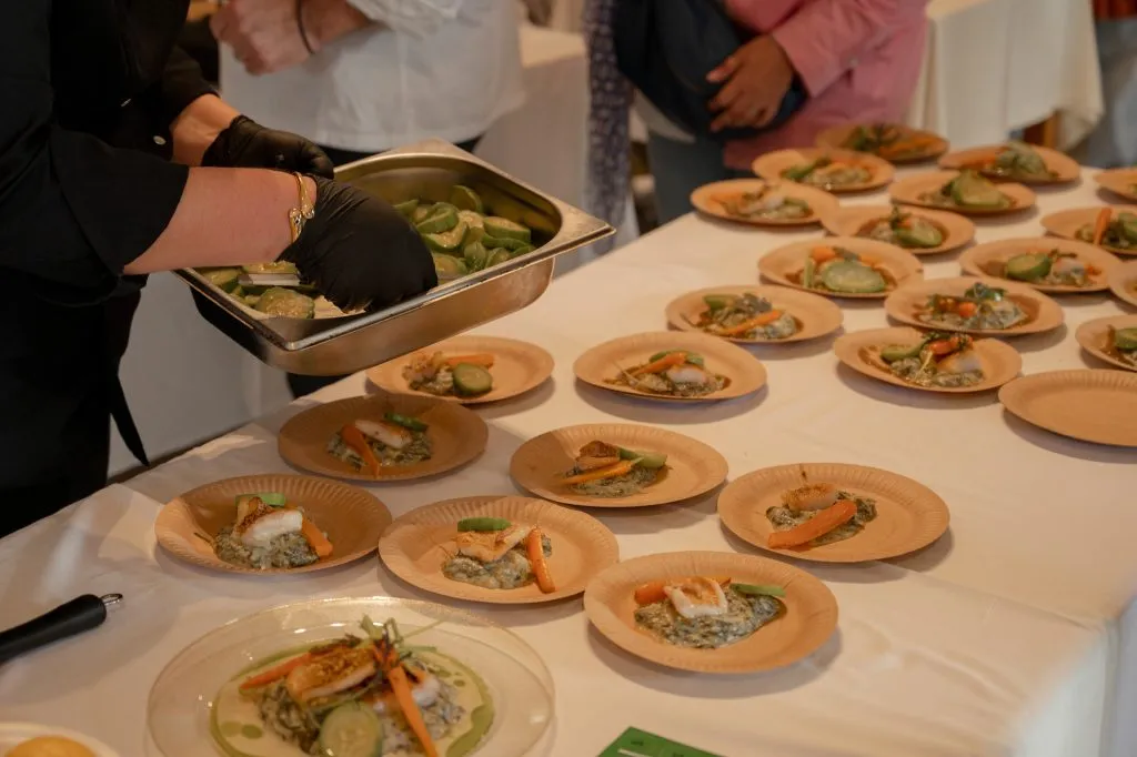 Chef preparing individual plates of lionfish dishes at the record-breaking tasting event on Santorini.