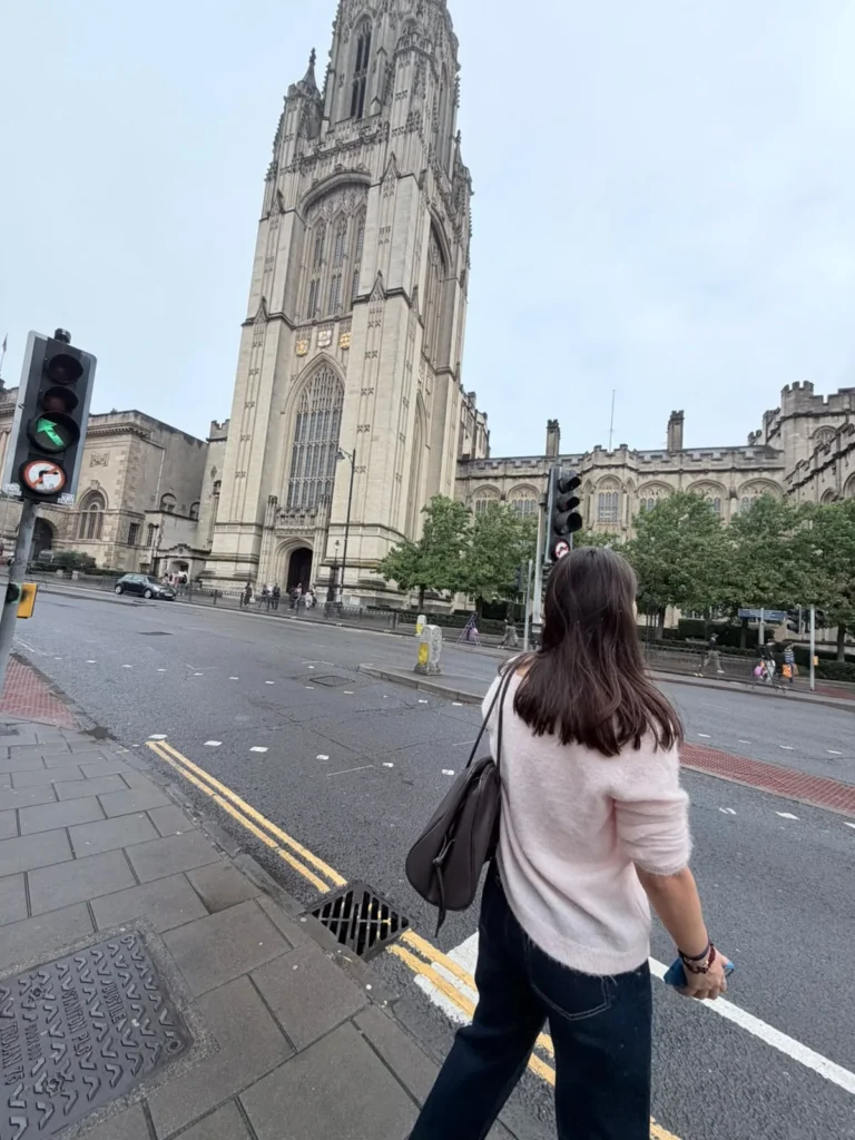 Student walking towards a university tower