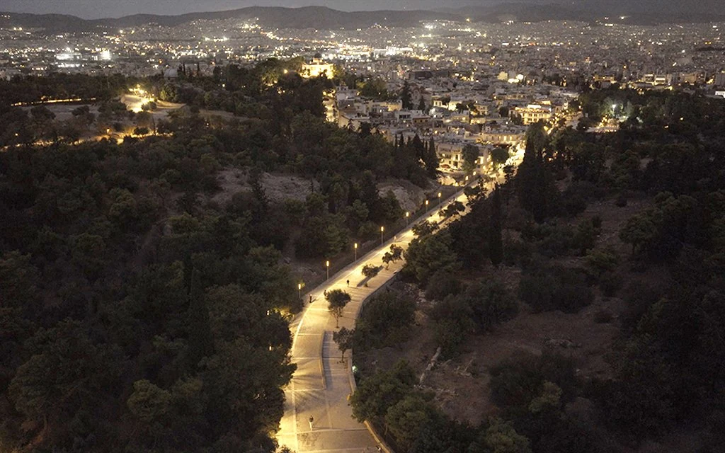 Elevated view of Athens’ historic promenade illuminated by a line of street lights at dusk