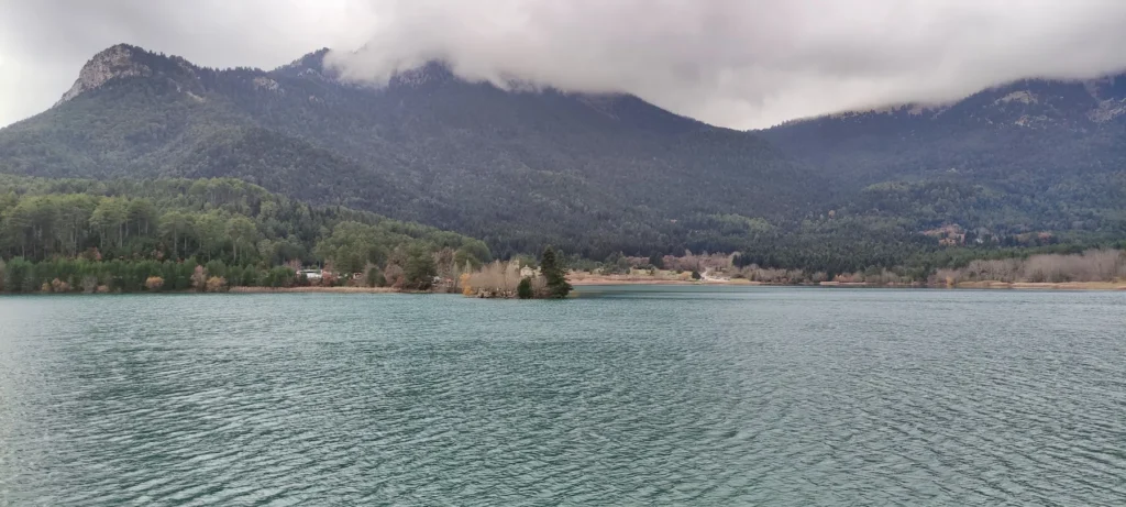 Lake Doxa beneath cloud-covered mountains in Feneos