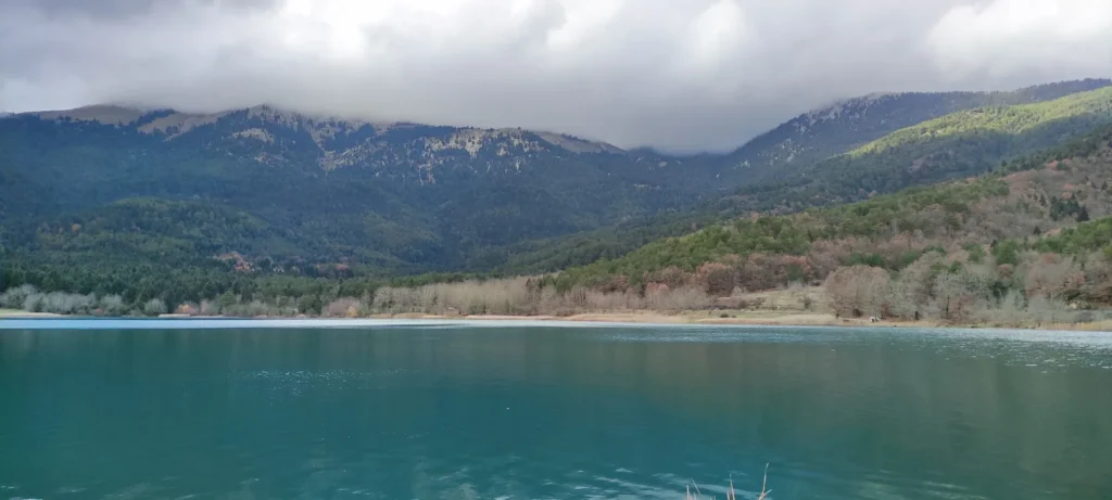 Turquoise waters of Lake Doxa beneath the mountains of Feneos